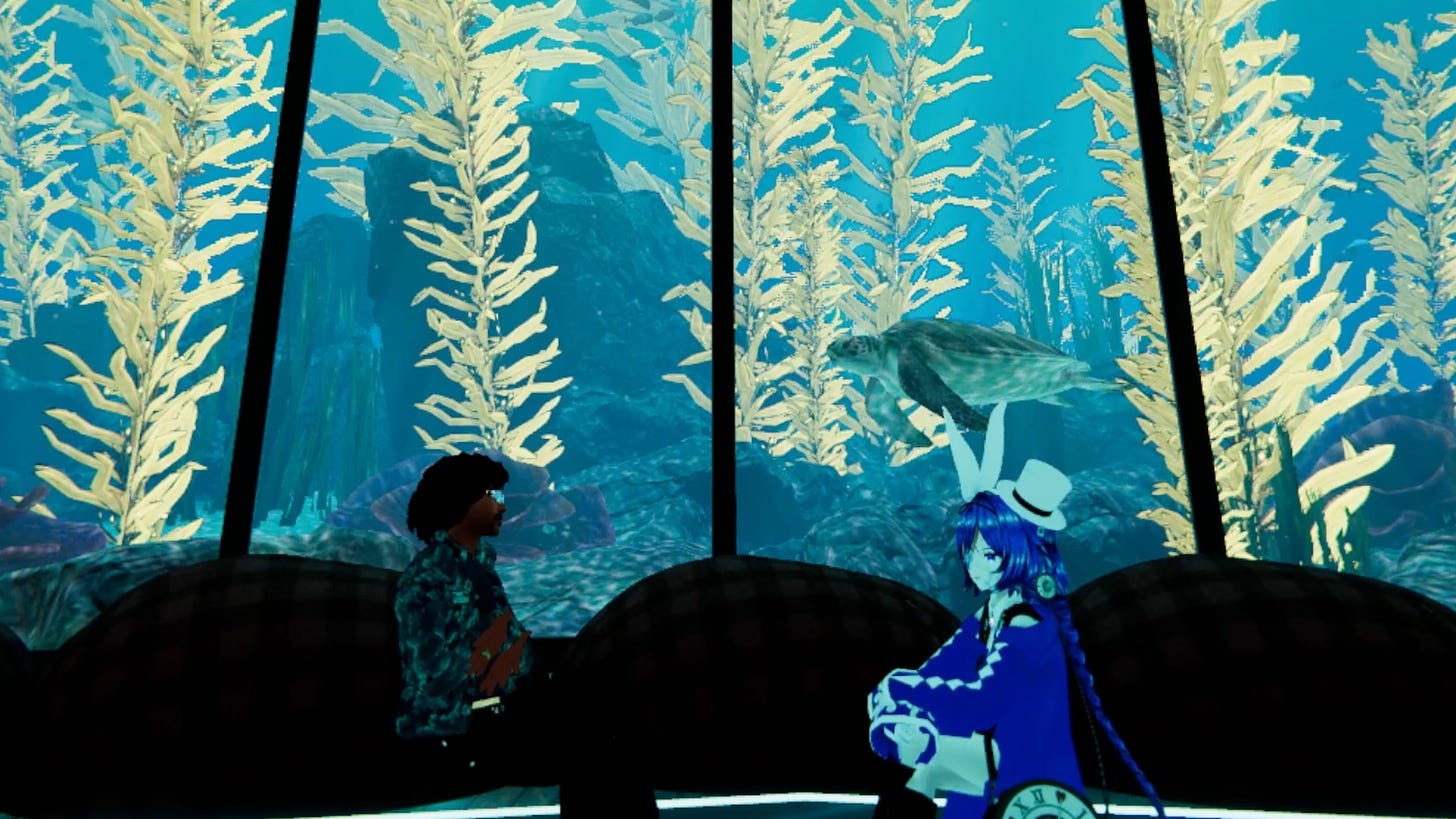 ArmaniXR and Fins sit and chat in front of a view of a sea turtle overlooking the seafloor.