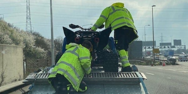 Two officers loading scramblers onto a flatbed truck