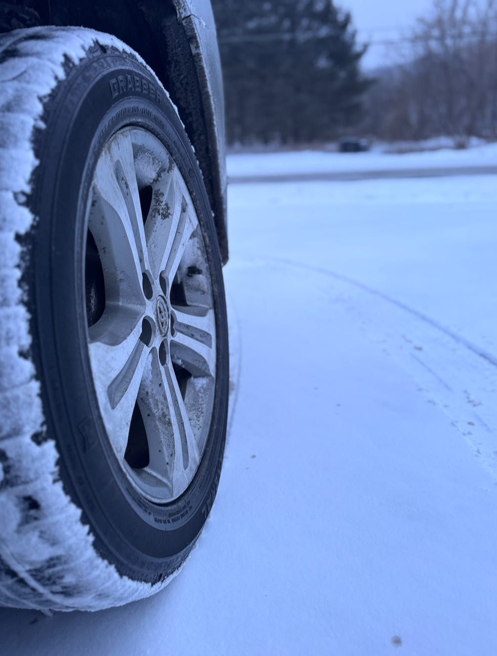 A close up of a car tire covered in snow.