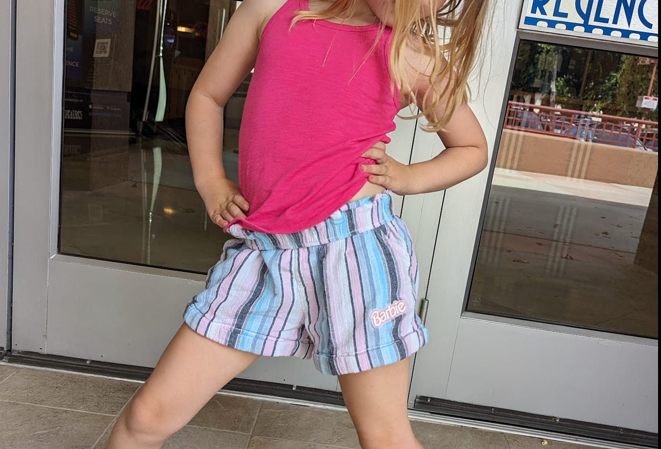 blonde child showing her Barbie shorts