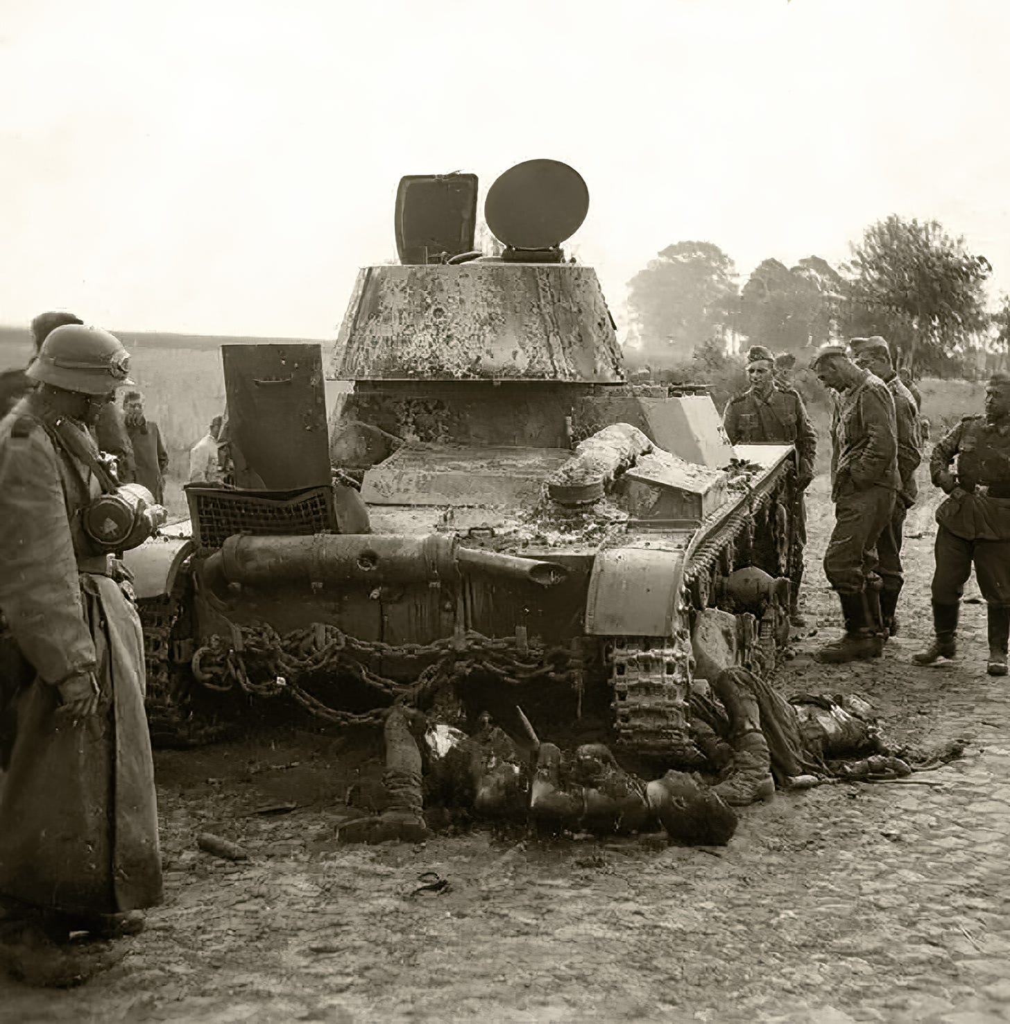 Two young soldiers lie sprawled in death beside their wrecked tank