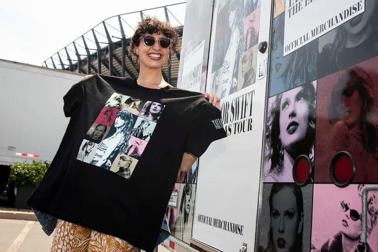 Elizabeth Estrada, 32, shows off some of the merchandise she purchased in Lot K for the Taylor Swift Eras tour a day before the concert at Lincoln Financial Field in Philadelphia, PA on Thursday, May 11, 2023.