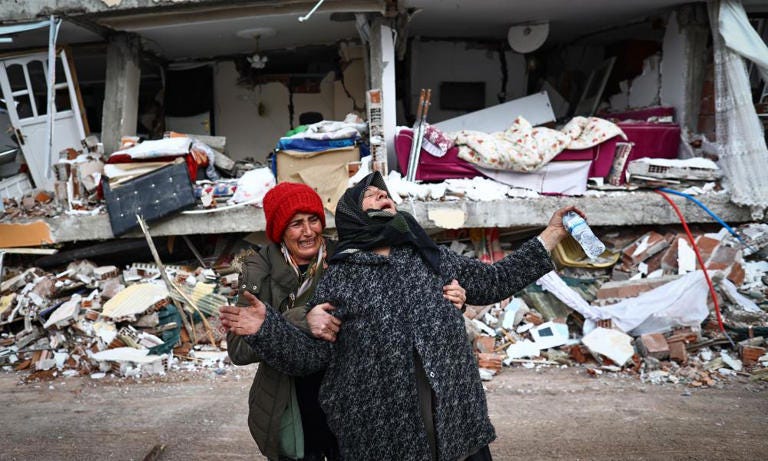 Two women at the site of a collapsed building in the Elbistan district of Kahramanmaraş. Photograph: Sedat Suna/EPA