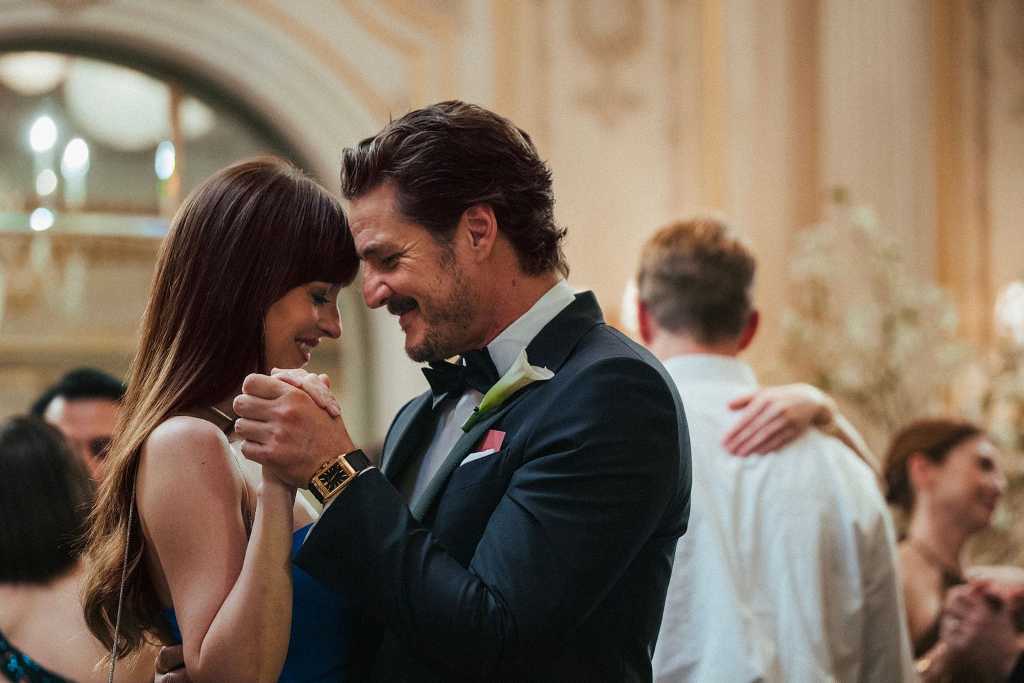 Dakota Johnson and Pedro Pascal in a still from the new movie Materialists. They are dancing and smiling at a wedding, with their heads touching. (A24) Dakota Johnson and Pedro Pascal in a still from the new movie Materialists. They are dancing and smiling at a wedding, with their heads touching. (A24)