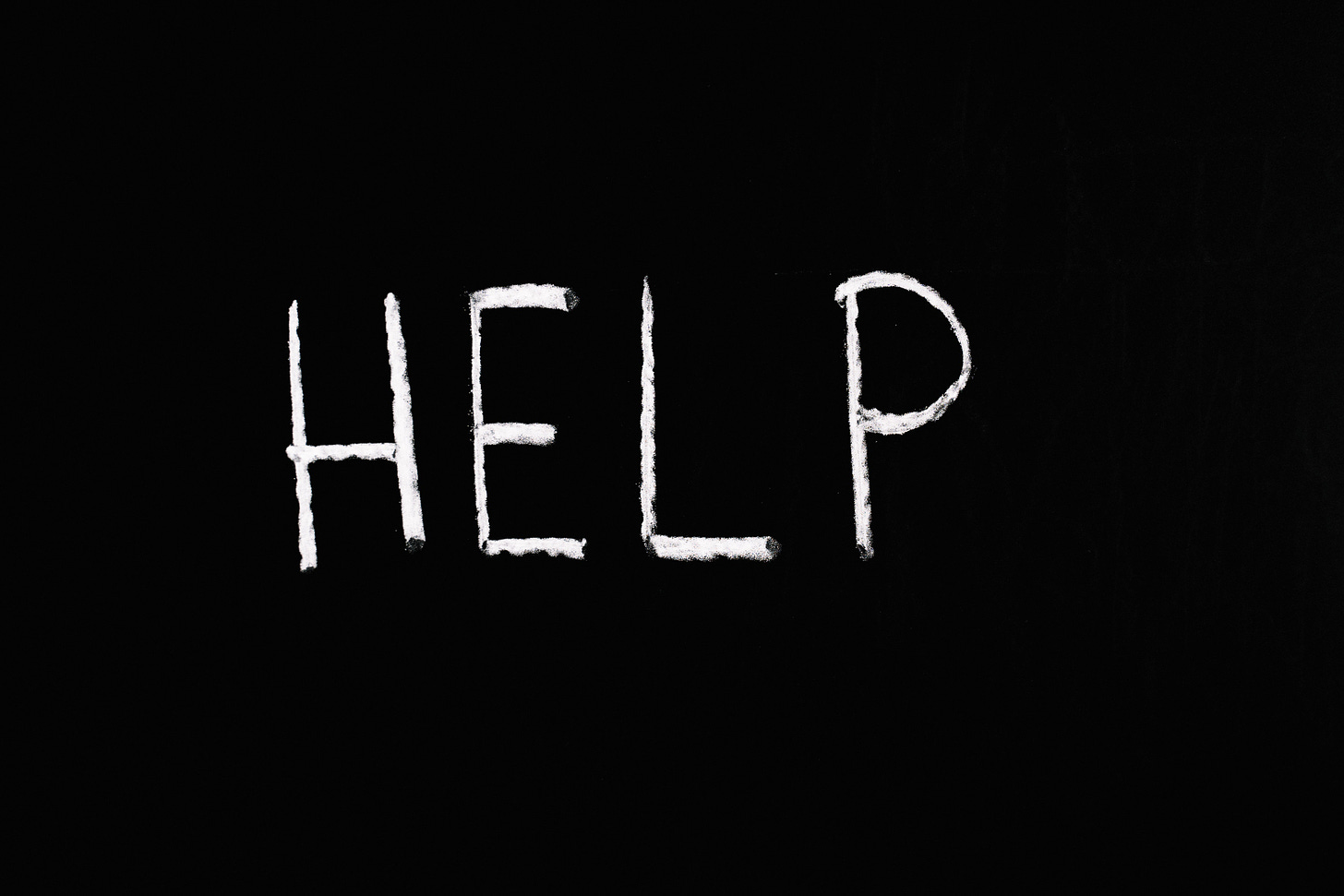 The word "Help" written in white chalk on a black background