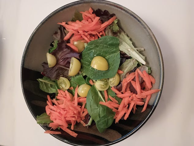 salad of spring mix with chopped yellow cherry tomatoes and grated carrots