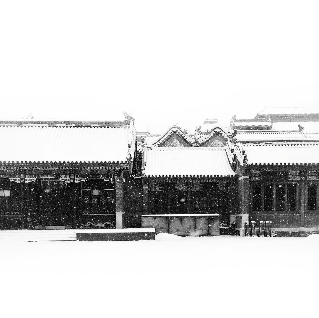 Snow falls over buildings along Beijing's historical Guozijian Street.