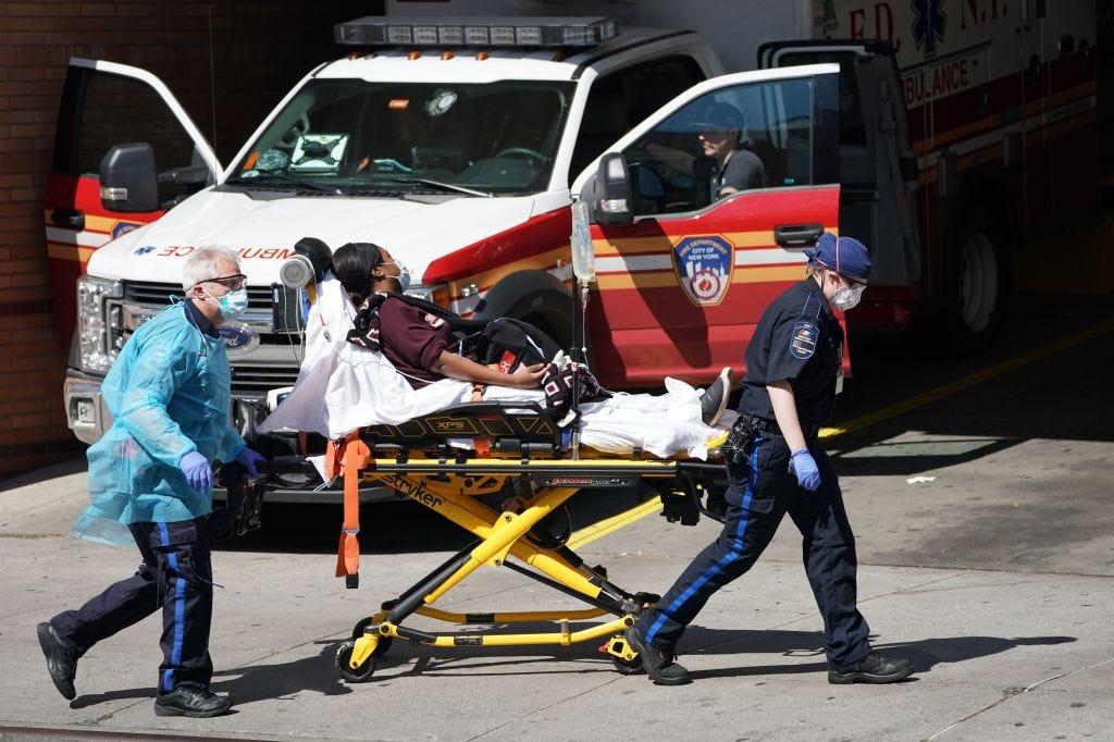 Emergency Medical Technicians pushing a stretcher with a patient into Wyckoff Hospital in Brooklyn, New York on April 6, 2020.