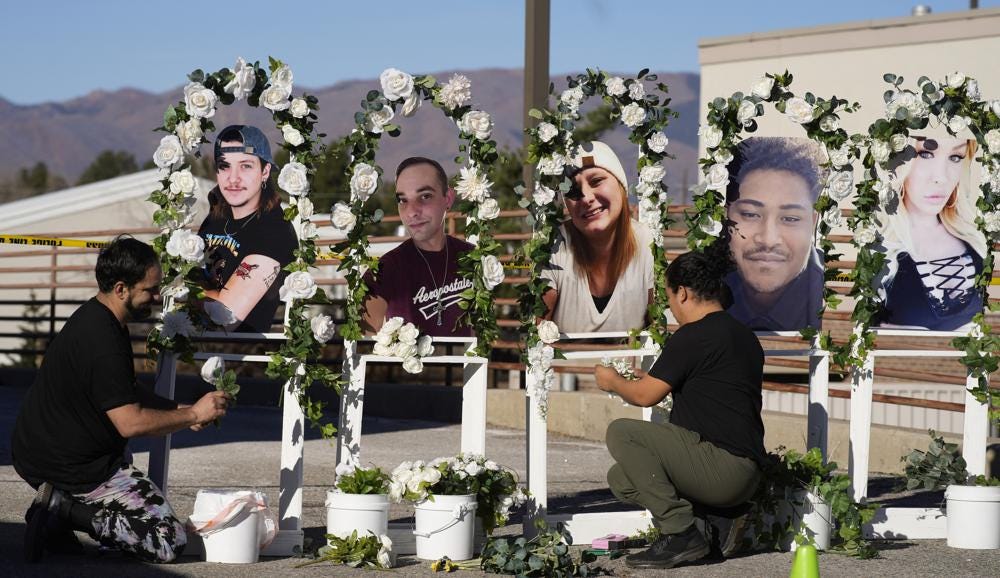 FILE - Noah Reich, left, and David Maldonado, the Los Angeles co-founders of Classroom of Compassion, set up a memorial near Club Q in Colorado Springs, Colo., on Nov. 22, 2022, with photographs of the five victims of a mass shooting at the gay nightclub. (AP Photo/David Zalubowski, File)