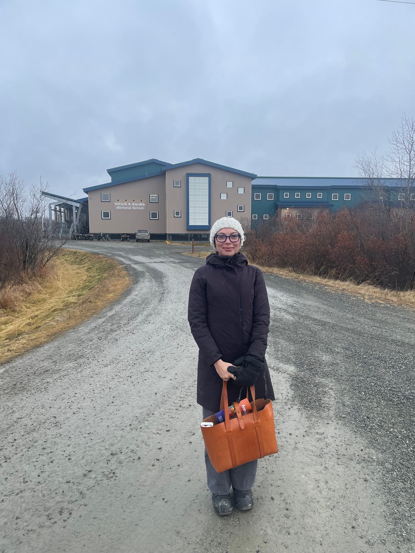 Image of Löki standing in front of the local school in Kwethluk, Alaska