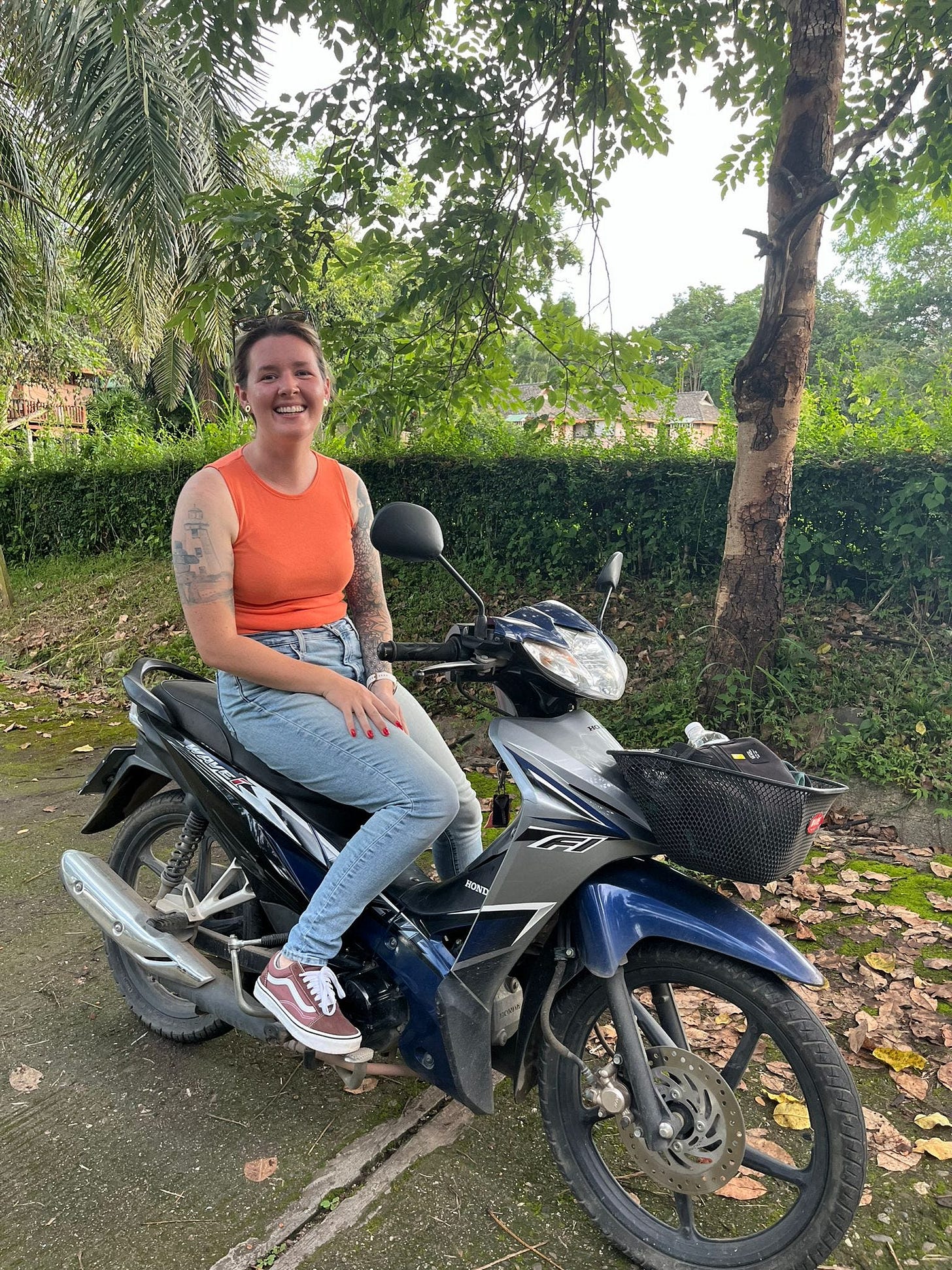 Guest author, Kaitlyn Ramsay, smiling from the seat of her blue motorbike