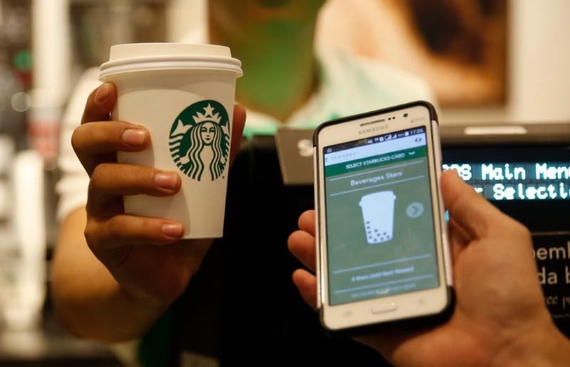 Image d'une personne payant son café Starbucks avec son smartphone