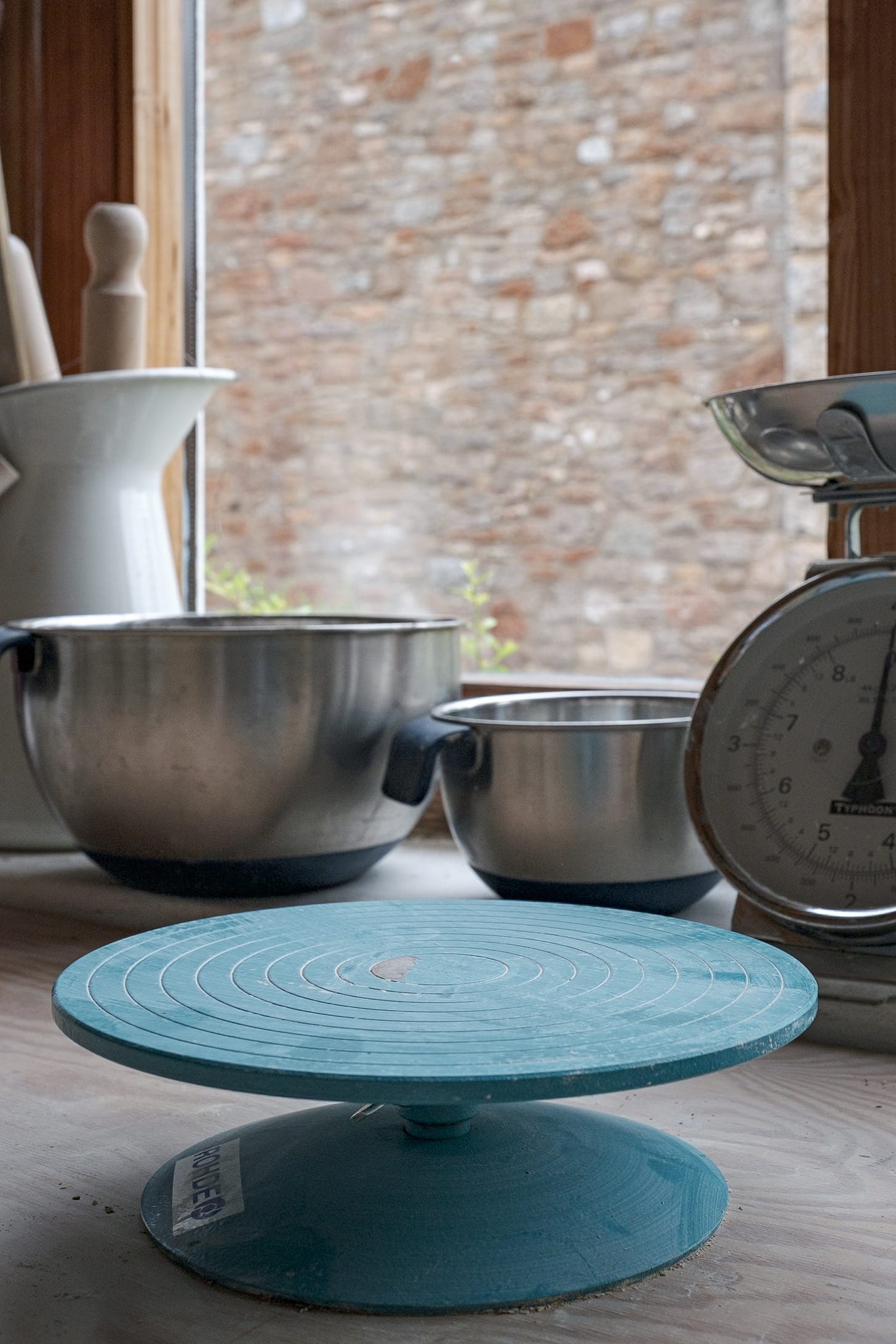 Rhode pottery turntable on workbench in front of scales, mixing bowls and jug with rolling pin