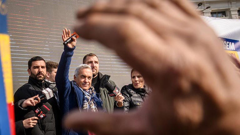 FILE: Romanian ultranationalist politician Calin Georgescu waves to supporters gathered for a protest outside the Romanian parliament in Bucharest, 22 February 2025