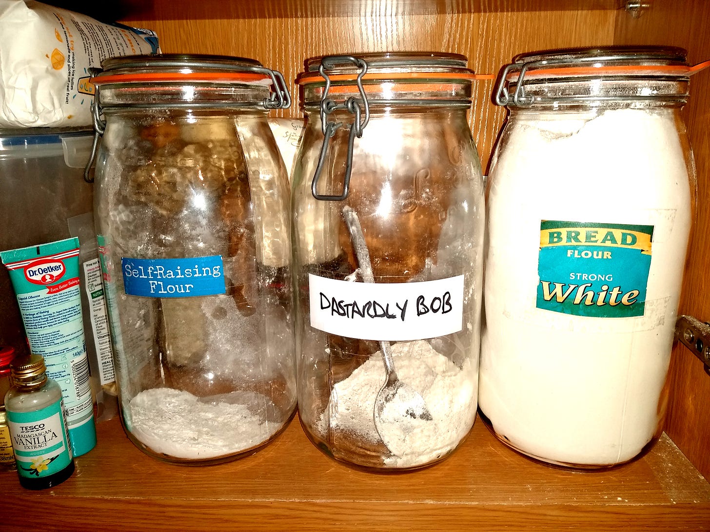 A photo of three large jars containing flour