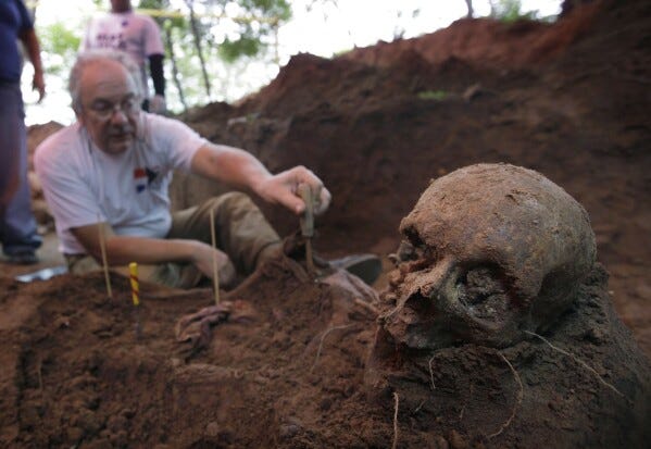 Rogelio Goiburu, a member of Paraguay's Truth and Justice Commission, looks at skeletal remains found buried as they are excavated at the National Police Special Forces headquarters in Asuncion, Paraguay, March 19, 2013. Goiburu's father, an opponent of the Stroessner dictatorship, went missing in 1977. (AP Photo/Jorge Saenz, File)