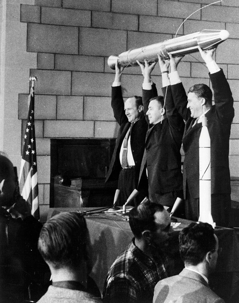 William Hayward Pickering, James Van Allen, and Wernher von Braun display a full-scale model of Explorer 1 at a crowded news conference in Washington, D.C. after confirmation the satellite was in orbit.