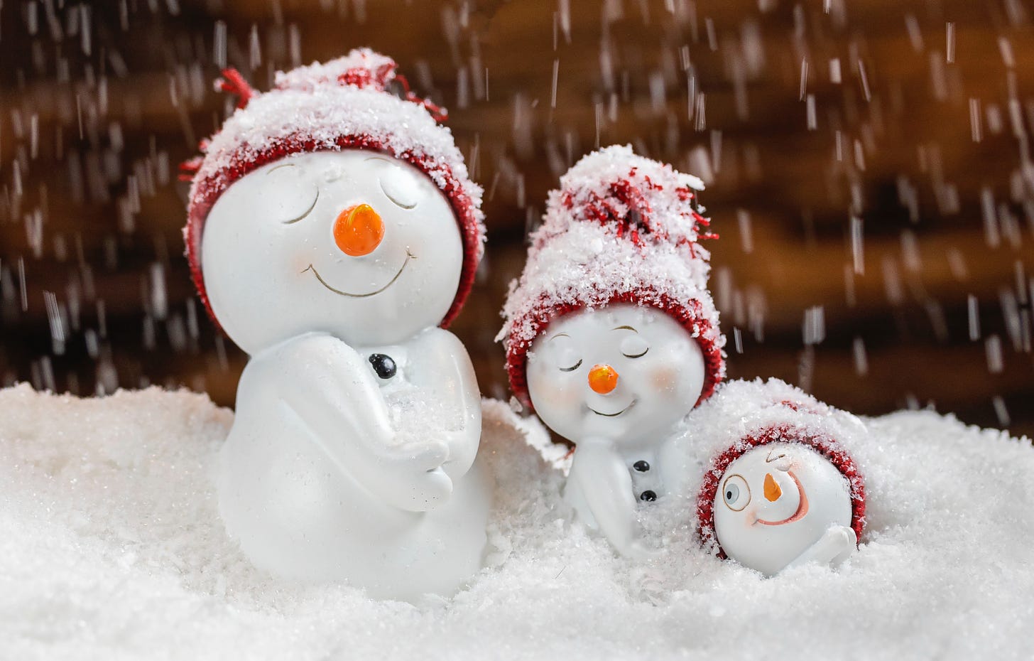 three little snowmen figures in snow 