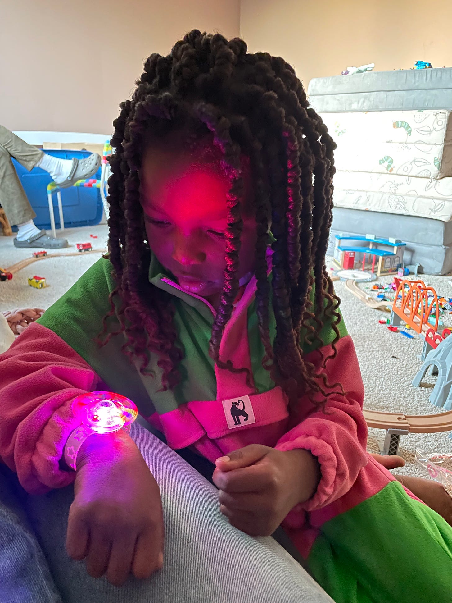 A Black child tries on a light-up bracelet