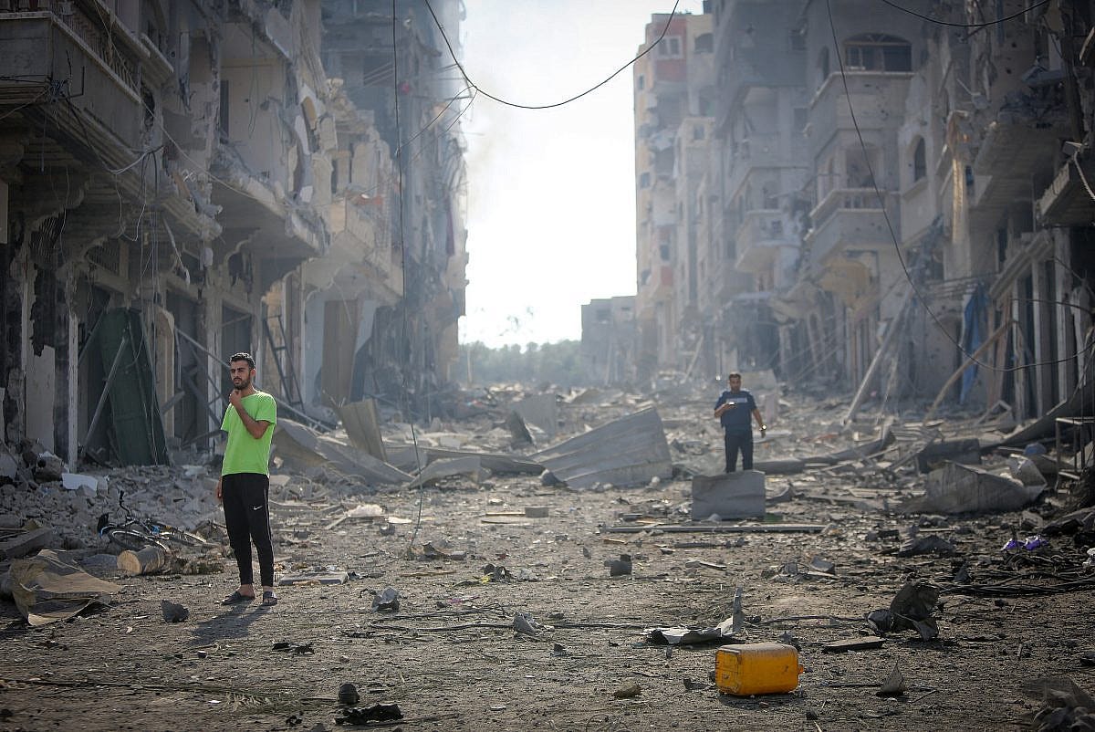 Palestinian walk through the rubble of houses destroyed by Israeli airstrikes in the Jabalia area in the northern Gaza Strip, October 11, 2023. (Atia Mohammed/Flash90)