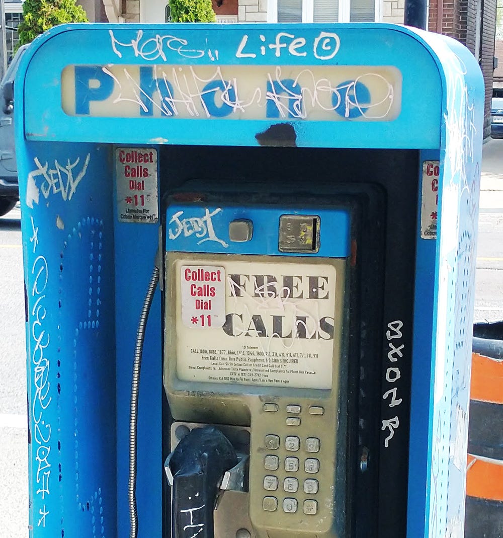 Non-functioning pay phone covered in graffiti