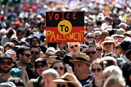 Crowds hold up a placard of the Australian Aboriginal Flag during a "Walk for Yes" rally in Melbourne on September 17, 2023