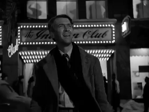 scene from the movie It's a Wonderful Life when George Bailey looks around, confused, in front of flashing lights