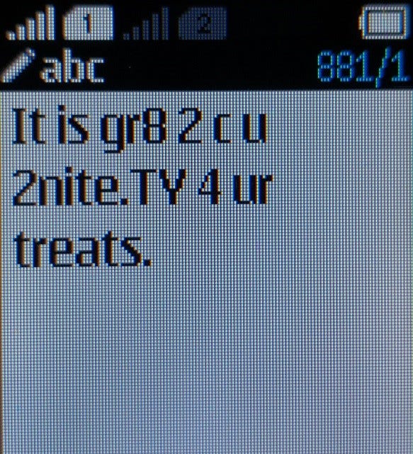 Close-up of a phone screen showing a text saying: "It is gr8 2 c u 2nite. TY 4 ur treats. Close-up of a phone screen showing a text saying: "It is gr8 2 c u 2nite. TY 4 ur treats.