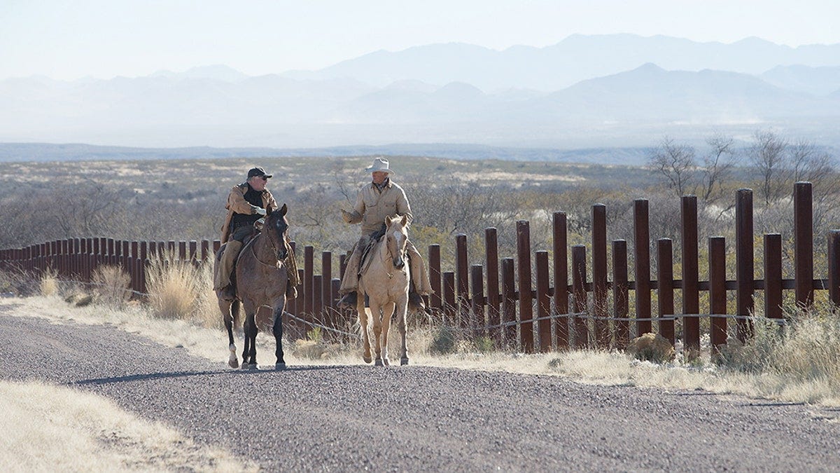 Howard Buffett speaking to a rancher whose property sits alongside border fencing in Arizona.