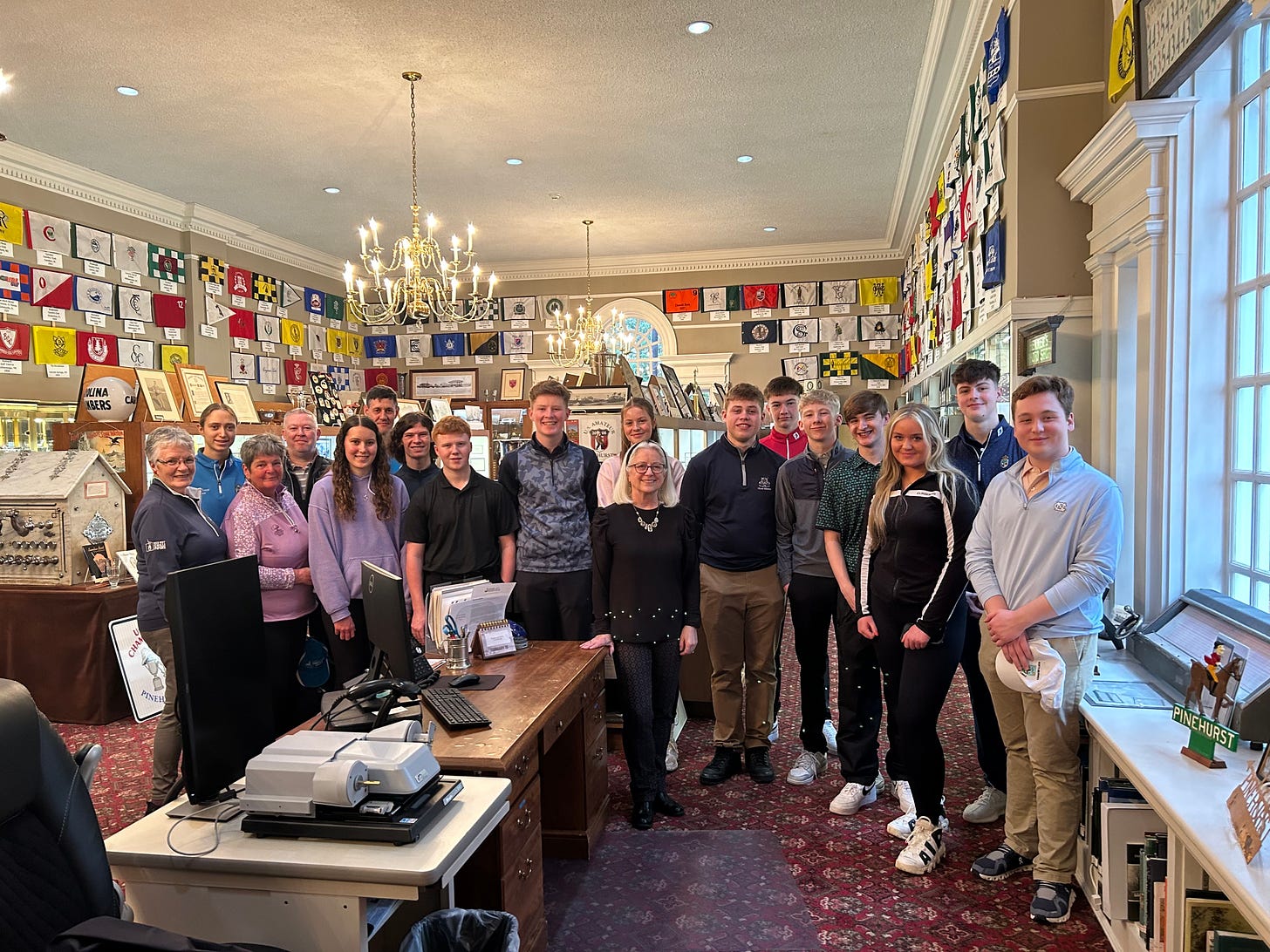All of the juniors, plus Steve, Sue, Shona, Gareth, and I, pose with the head of the Tufts Archives at Pinehurst. Numerous pin flags from Donald Ross-designed courses are in the background.