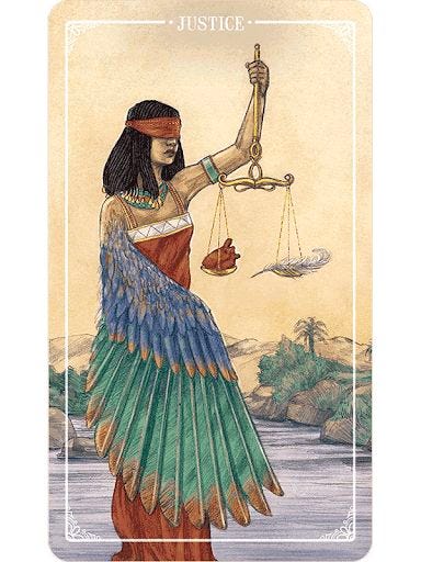 The Justice Tarot card depicting the goddess Ma'at blindfolded, holding the scales of judgement, which weigh a heart against a feather.