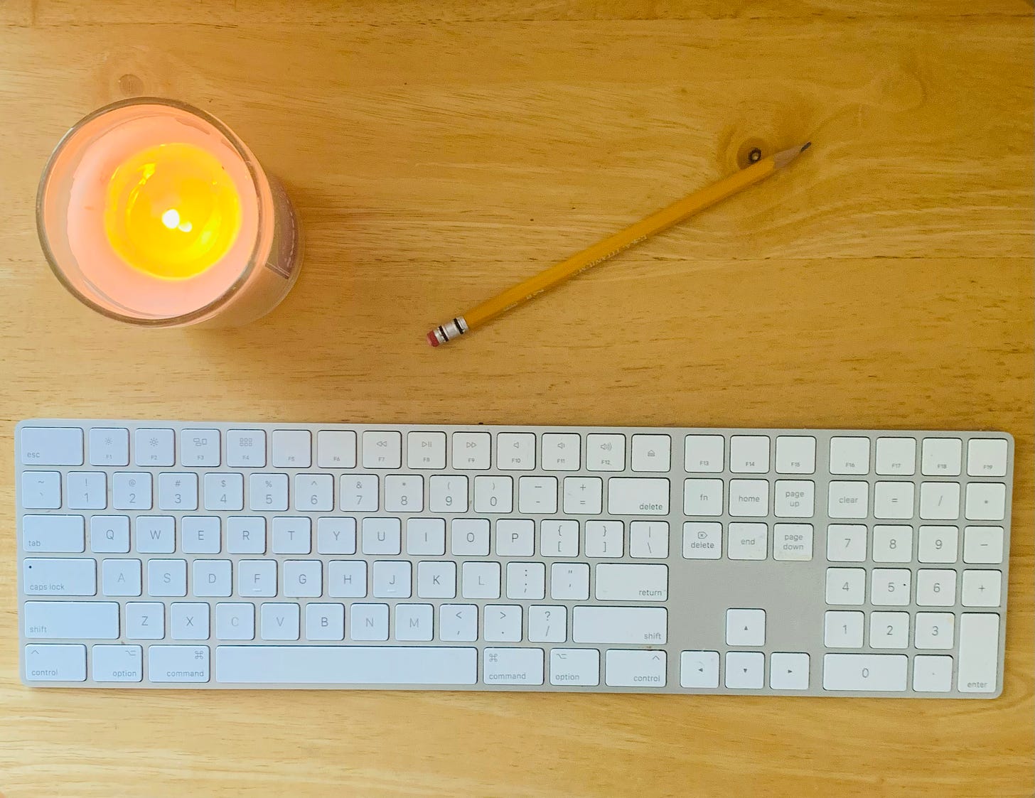 keyboard, pencil, candle on a wood table