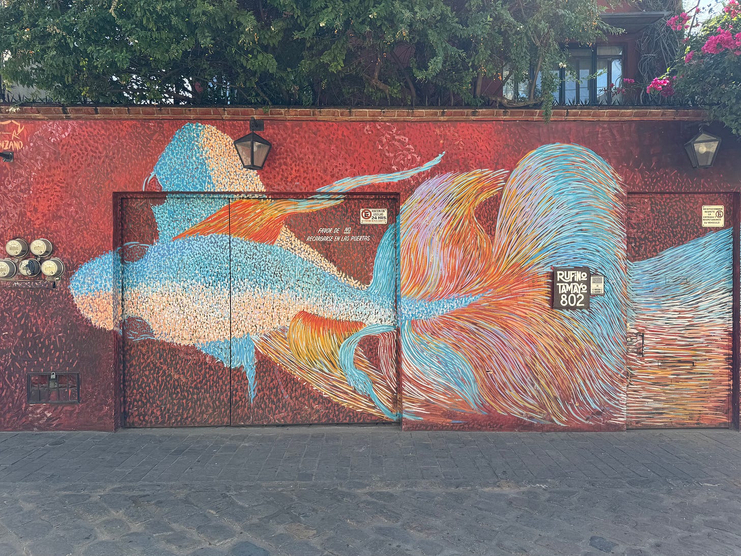 A mural covering a wall made up of two swimming fish painted in the Impressionist style.