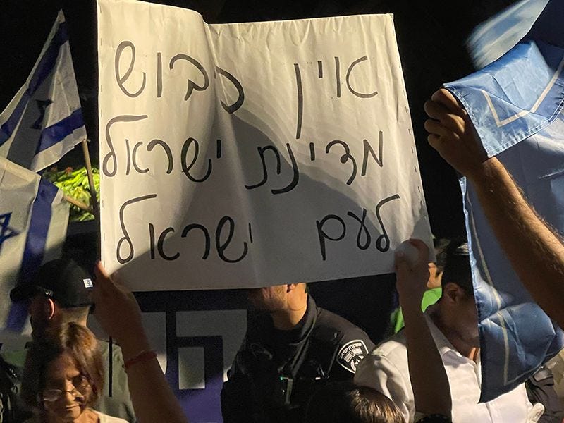 Right-wing protesters hold up a sign reading "There is no occupation. The State of Israel is for the people of Israel." (Photo by Vivian Bercovici)
