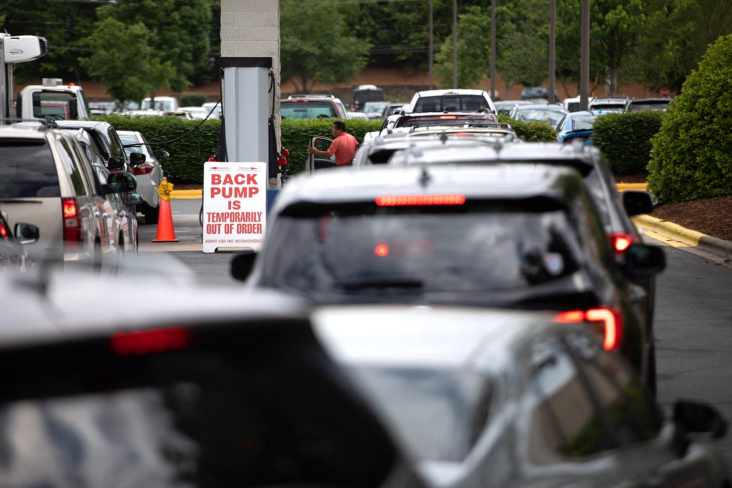 Long line of cars at the gas pump.