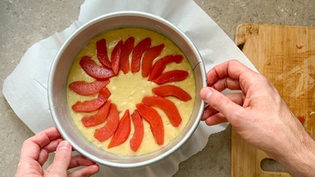 Quince cake topped with pink poached quince slices about to head into the oven.
