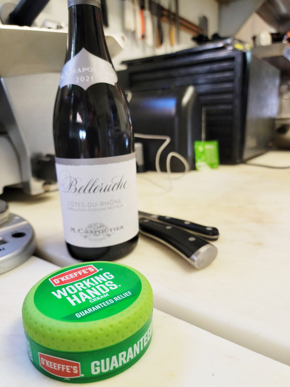 A can of hand lotion, a bottle of wine on the kitchen counter. 