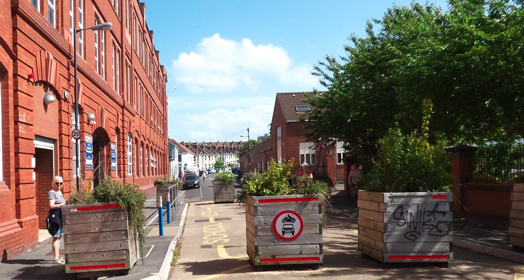 3 large planters, full of plants, block a road