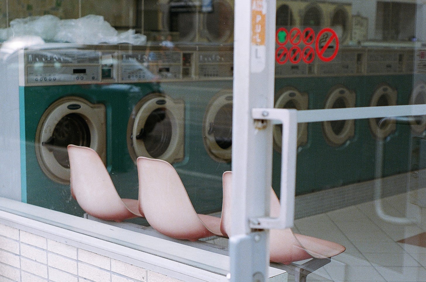 pale pink chairs in laundromat with teal washing machines
