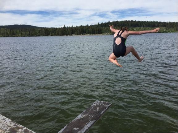 Fille sautant dans un lac