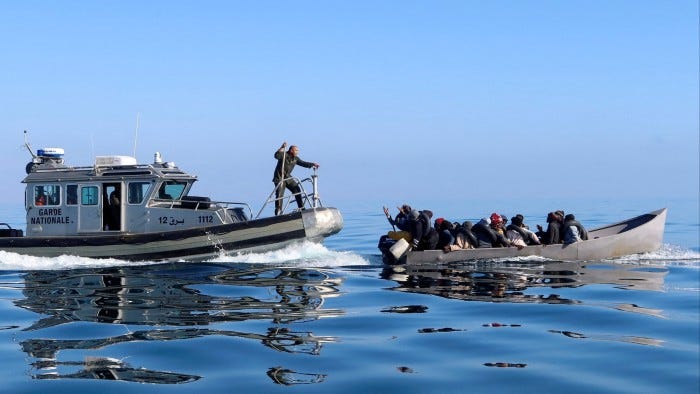 Tunisian coast guards try to stop migrants at sea during their attempt to cross to Italy,