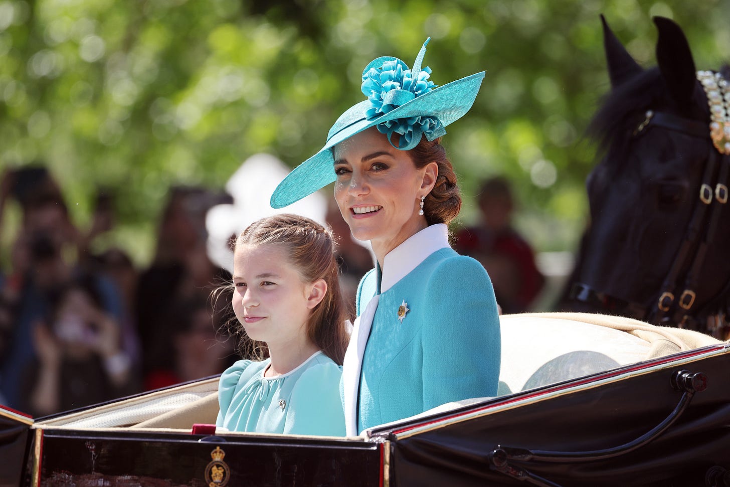 Princess Kate and Princess Charlotte in a carriage wearing smart blue outfits