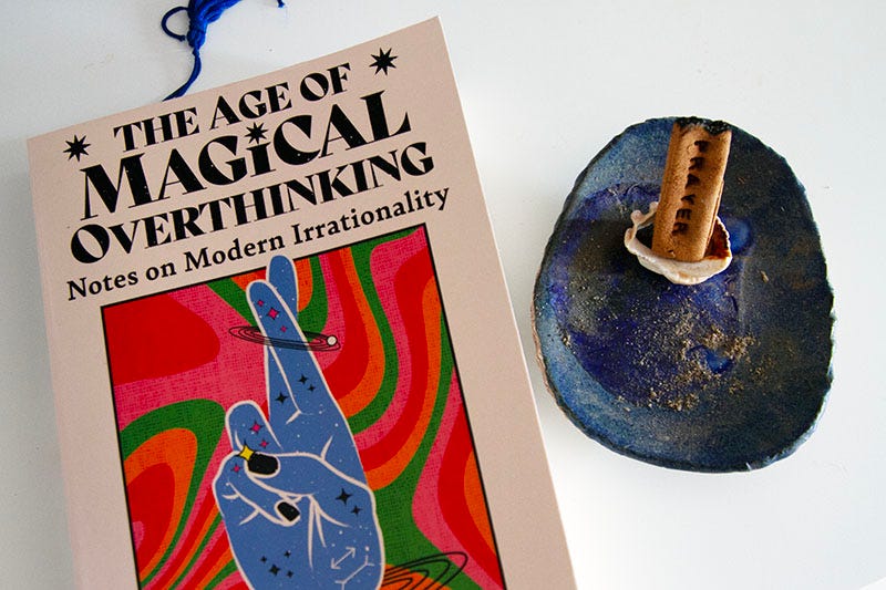 A copy of Amanda Montell’s ‘The Age of Magical Overthinking’ alongside an insence stick, with the word ‘prayer’ inscribed on it.