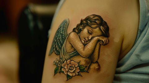 Photo of a very sweet girl angel, inked on the upper arm of a girl.