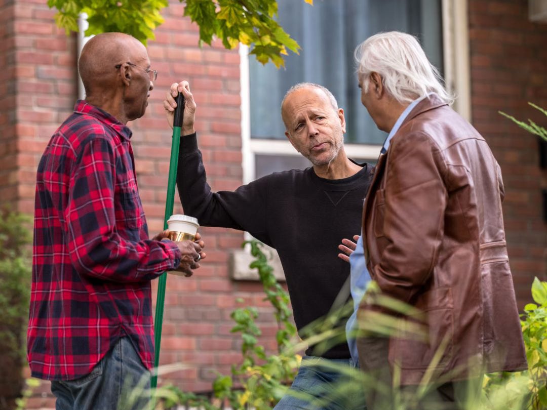 A photo of three men from different ethnic backgrounds, having a polite conversation.