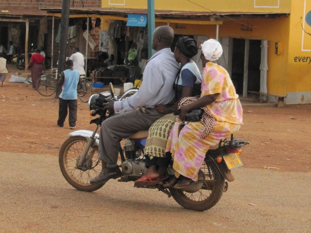 a man on a motorycle with two women on the back