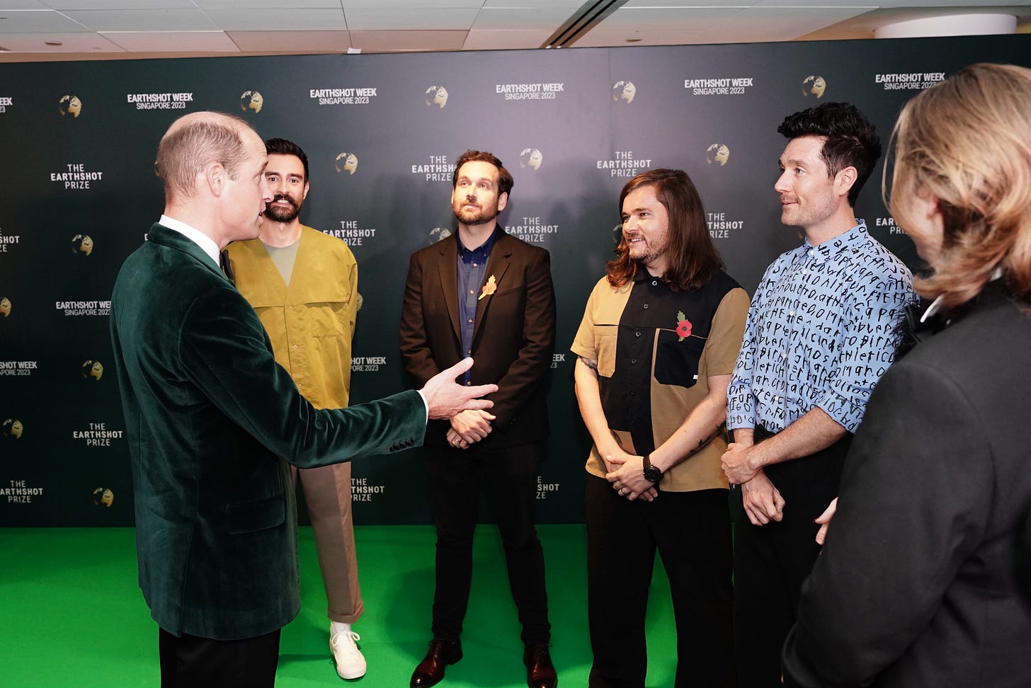 Prince William greets members of Bastille on green carpet