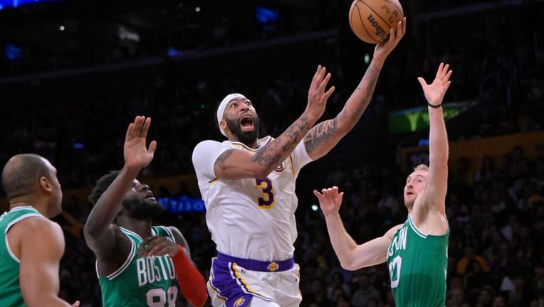 Anthony Davis #3 of the Los Angeles Lakers drives past Neemias Queta #88 and JD Davison #20 of the Boston Celtics in the first half at Crypto.com Arena on December 25, 2023 in Los Angeles, California. (Photo by Jayne Kamin-Oncea/Getty Images)