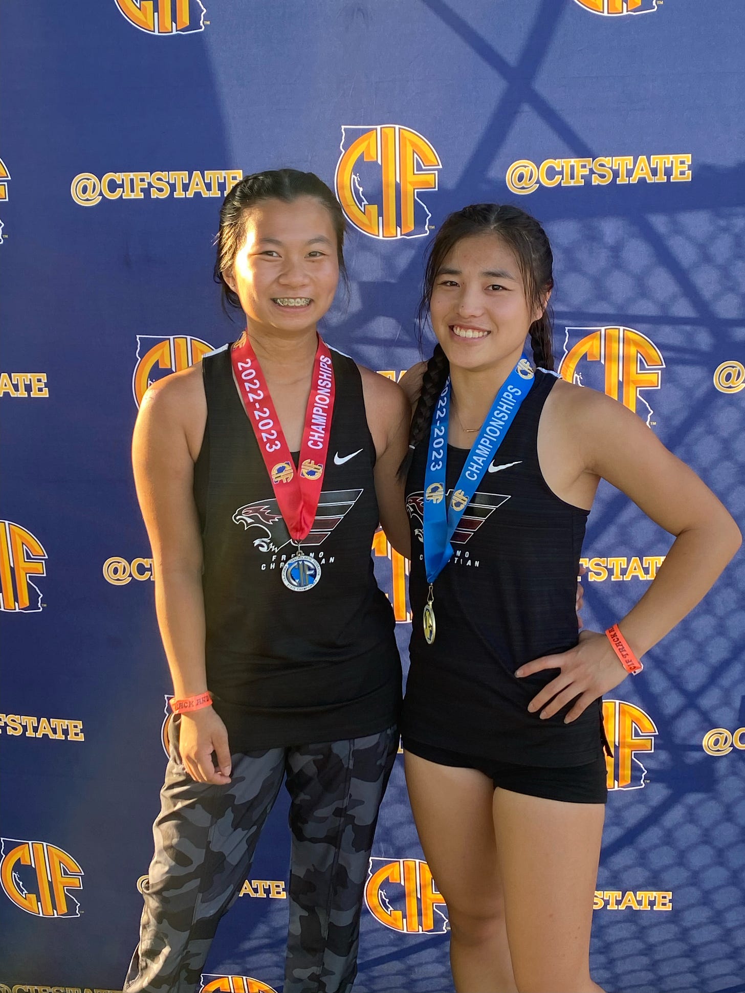 Two ambulatory athlete sisters pose with their medals at the State Championship.
