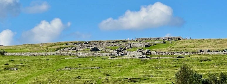 A green field with rocks and blue sky